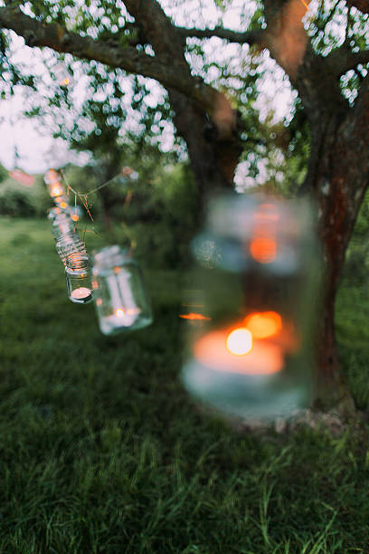istock Garland of jars with burning candle hanging on a tree 537412678