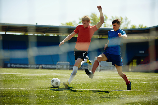 Two young sportsmen playing football
