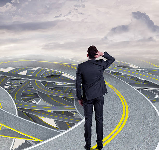 istock Confused businessman standing on tangled highway 537421488