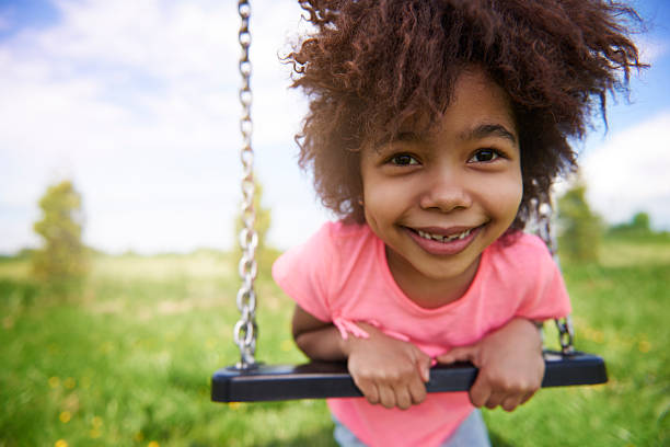 dziewczynka na plac zabaw - child swinging playground african descent zdjęcia i obrazy z banku zdjęć