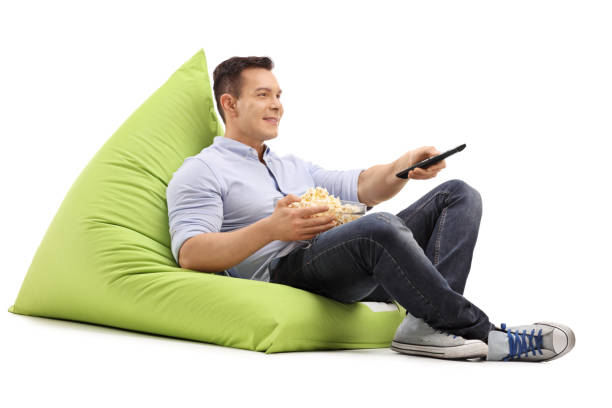 istock Guy watching TV seated on a beanbag 537424692