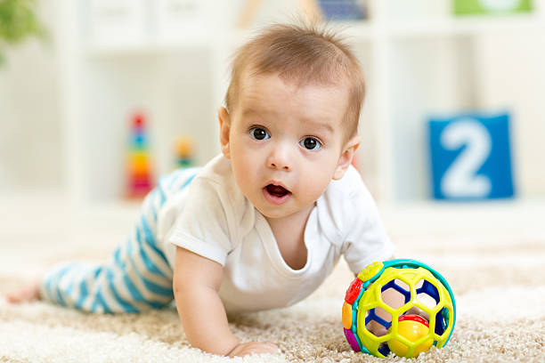 istock Joyful baby crawling on the floor in nursery room 537431380