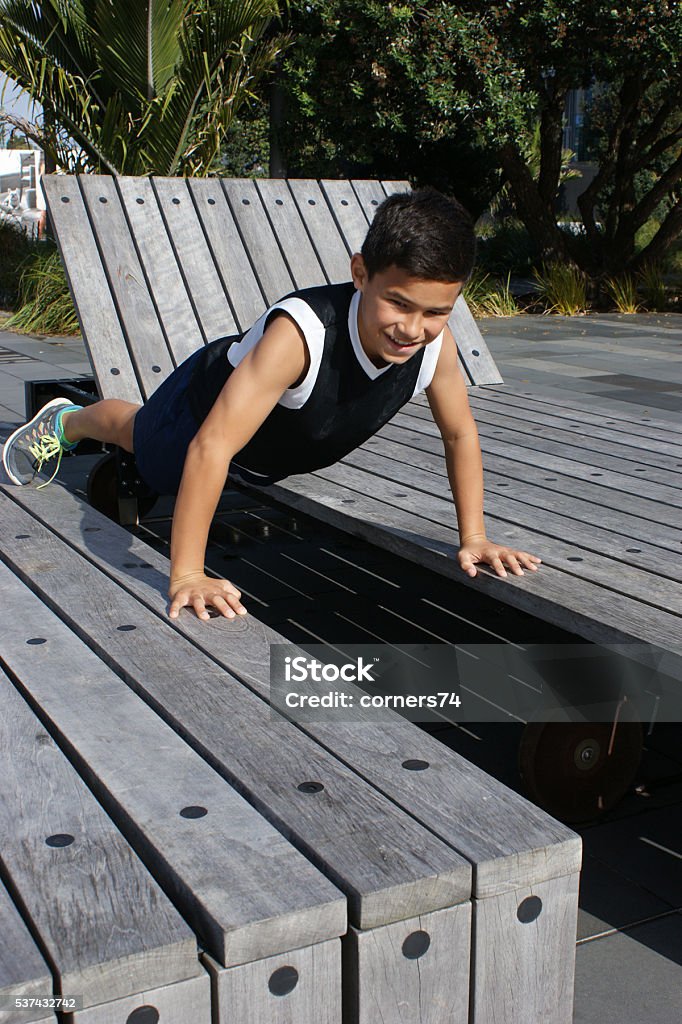 Boy working out in an urban park Boy working out on an installation in an urban park. Active Lifestyle Stock Photo