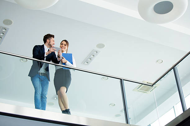 istock Below view of two business people using mobile phone. 537432944