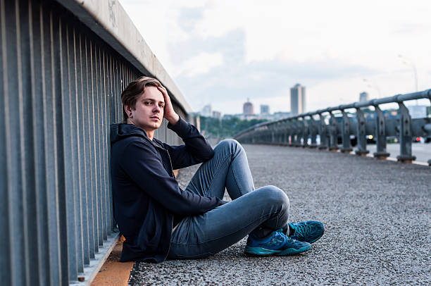 istock young man is sitting near fencing 537433730