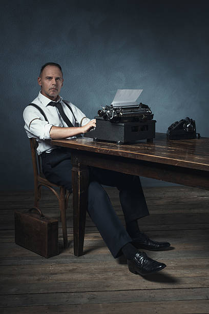istock Slumped sitting retro 1940 office worker behind desk with typewriter. 537433794