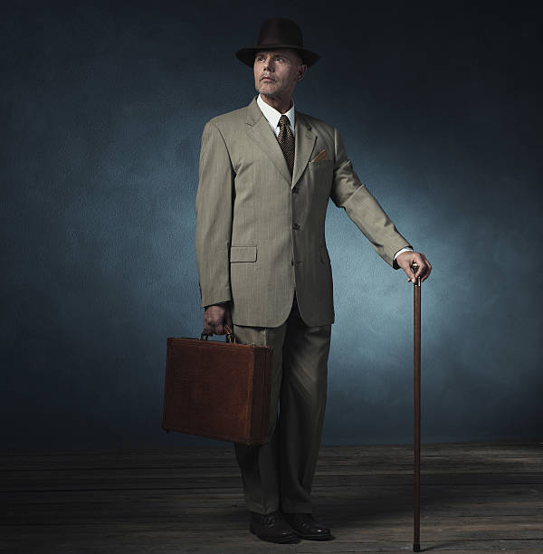 istock Vintage 1940 office worker standing with briefcase and cane. 537434714