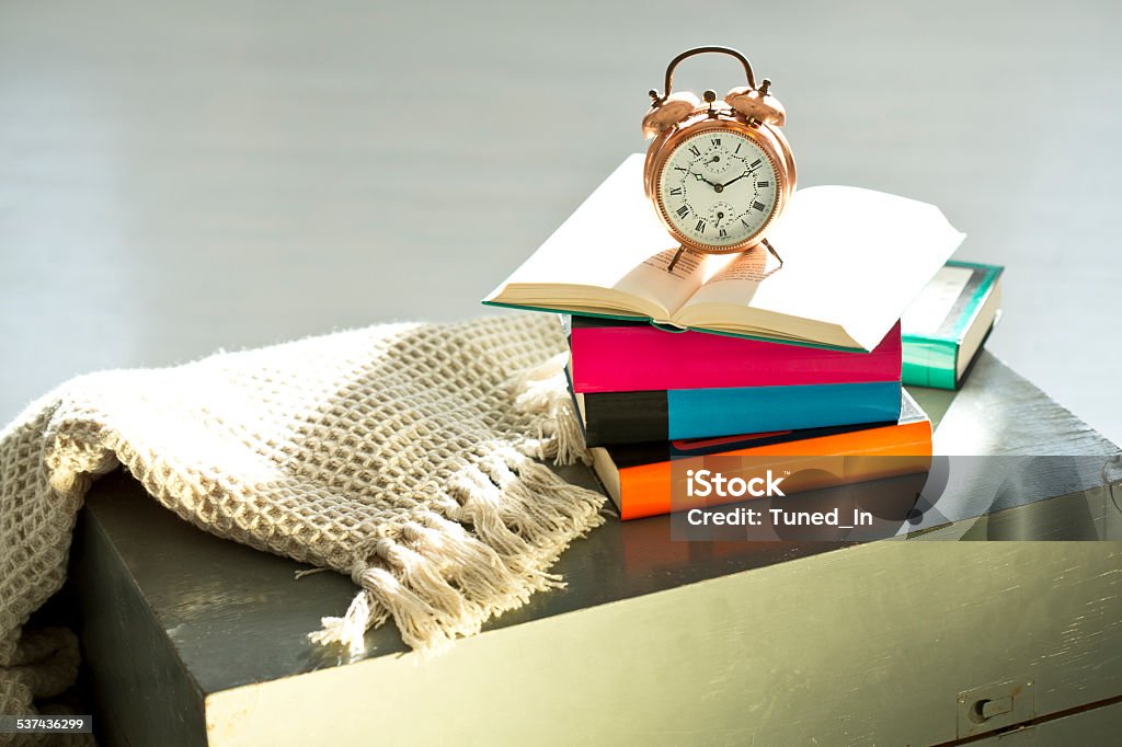 Bedtime reading, alarm clock and books Book Stock Photo