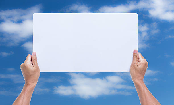 istock hands holding blank cardboard with blue sky background 537436797