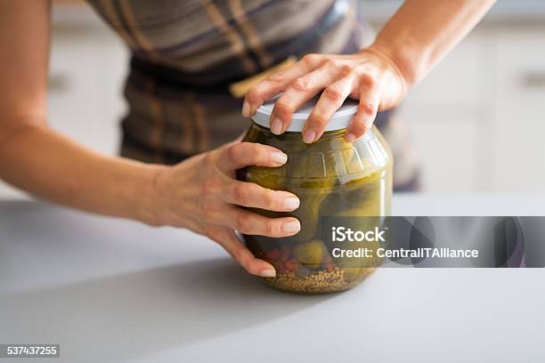 Closeup On Young Housewife Opening Jar Of Pickled Cucumbers Stock Photo - Download Image Now