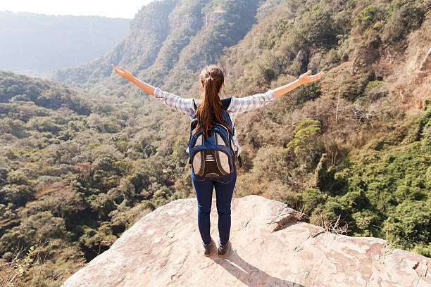 istock young woman arms open on mountain cliff 537437265