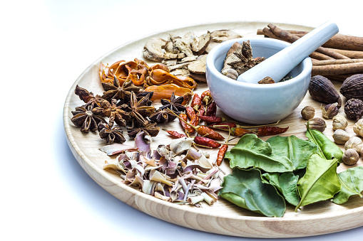 A photo of Herbal medicine in wood dish on white isolate background with space for text