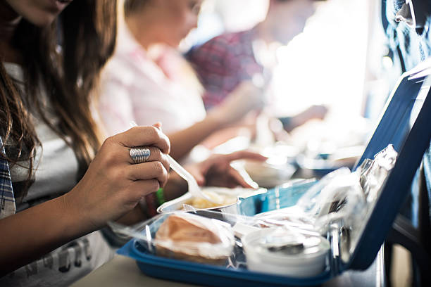 Meal in the airplane. Unrecognizable people eating lunch while traveling by airplane. passenger cabin photos stock pictures, royalty-free photos & images