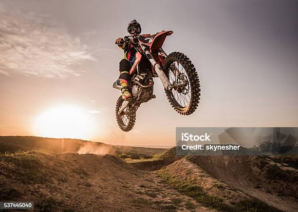 Motocross Rider Performing High Jump At Sunset Stock Photo - Download Image Now - Motocross, Motorcycle, Jumping