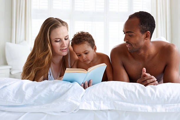 istock Parents with children reading story indoors. 537447284