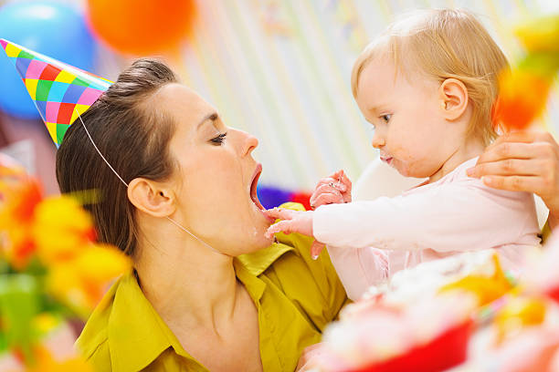 istock baby feeding mother with birthday cake 537449728
