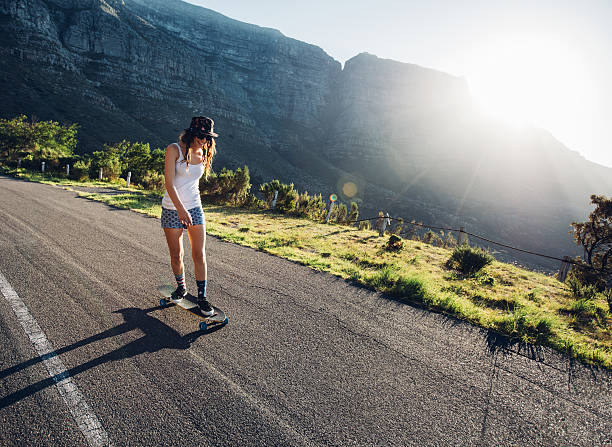 istock Young woman skating outdoors on rural road 537450838