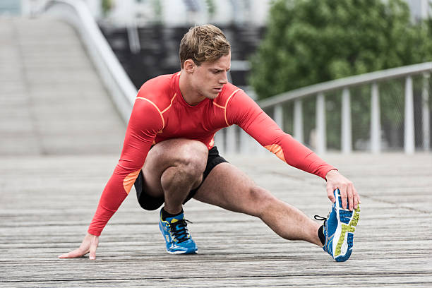 istock Young athletic man stretching outside on wooden bridge 537450942