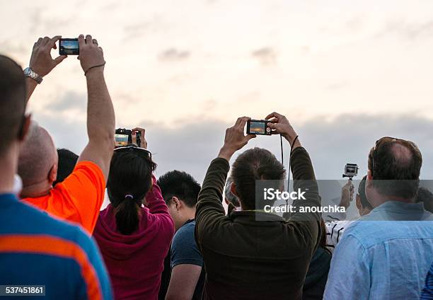 People In Crowd Photographing Sunset On Key West Stock Photo - Download Image Now - 2015, Adult, Apple Computers