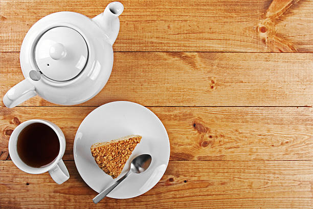 piece of cake and tea pot on brown wooden table