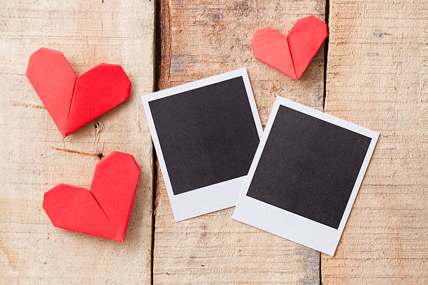 istock Instant photos with origami hearts. On wooden background 537452443