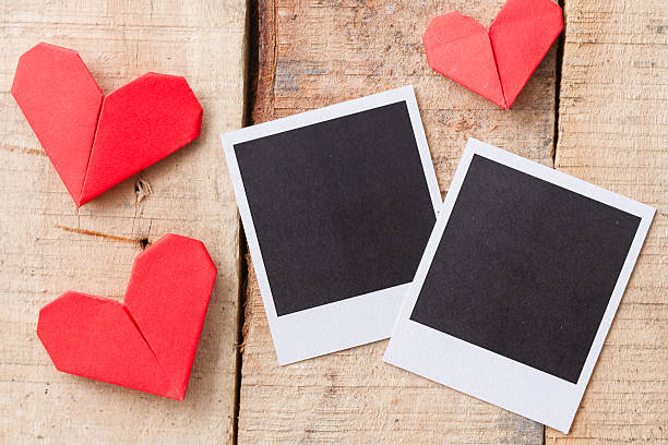 istock Instant photos with origami hearts. On wooden background 537452449