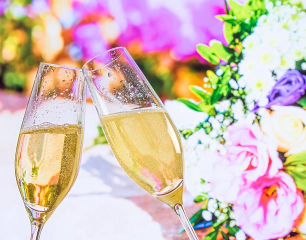 istock champagne flutes with golden bubbles on wedding flowers background 537452726