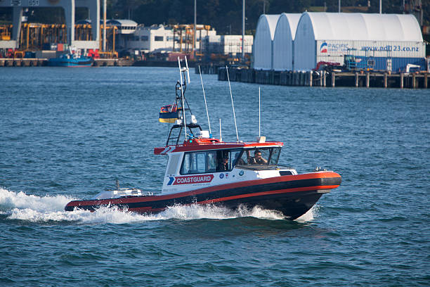 Auckland, New Zealand - January 19, 2015: A Coastguard New Zealand patrol boat cruises through the water between downtown Auckland and Devonport on the north island of New Zealand.