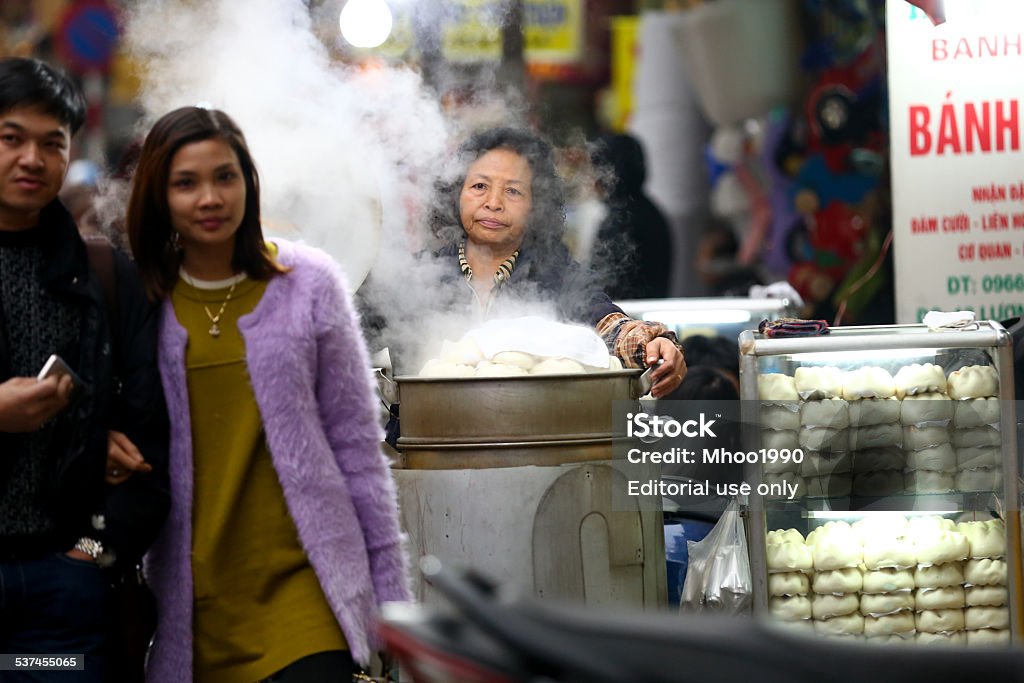 Vietnamese street vendor in Hanoi Hanoi, Vietnam - February 6, 2015: A vietnamese street vendor is carrying lots of stuff. 2015 Stock Photo