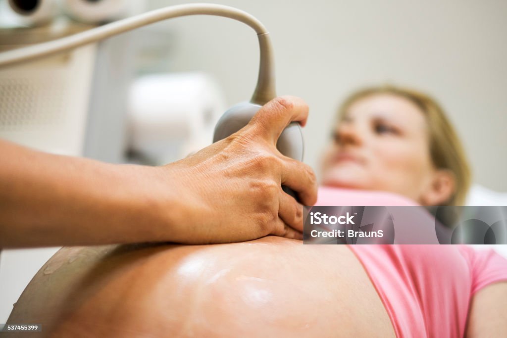 Woman on ultrasound exam. Unrecognizable gynecologist using ultrasound on pregnant woman. 2015 Stock Photo