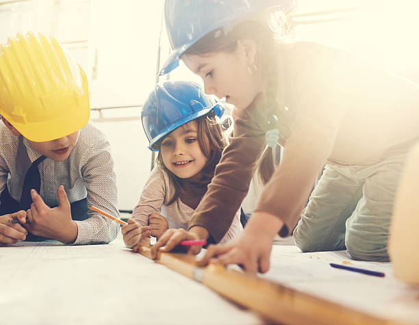 mały zespół inżynierów. - indoors blueprint smiling built structure zdjęcia i obrazy z banku zdjęć