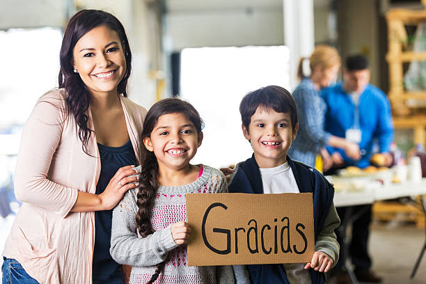 jovem hispânico família segurando placa de gracias - charity and relief work donation box thank you child - fotografias e filmes do acervo