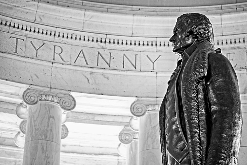 Bronze statue of Thomas Jefferson standing against tyranny inside the Jefferson Memorial in Washington DC.