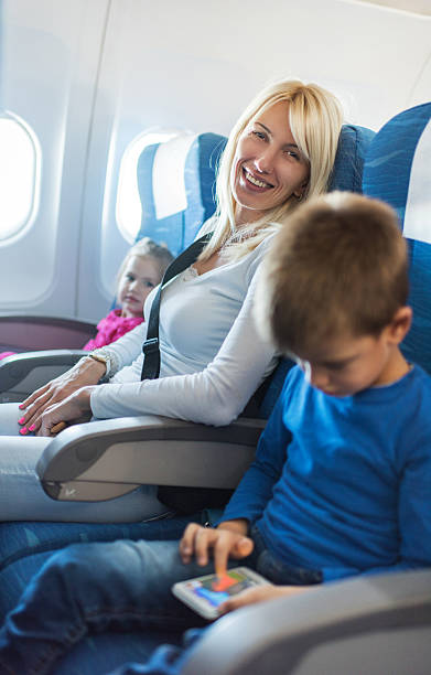 istock Mother and children in airplane. 537456359