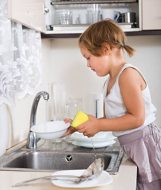 istock Cute little girl washing dishes 537456879