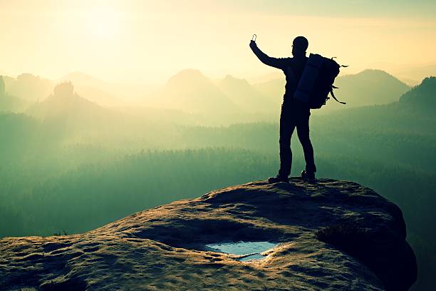 istock Strong hiker taking photo with smartphone, mountain peak 537458502