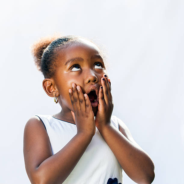 surpris de jeune femme africaine avec les mains sur le visage. - surprise child little girls shock photos et images de collection