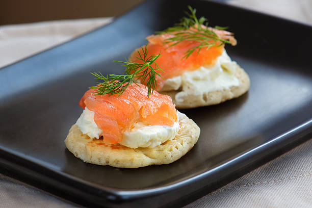 two blinis with salmon cheese and dill food photography appetizer two blinis with smoked salmon cream cheese and dill on top appetizer blini photos stock pictures, royalty-free photos & images
