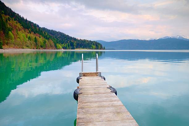 istock Empty wooden mole on  blue Alps lake, wharf for boats 537458648