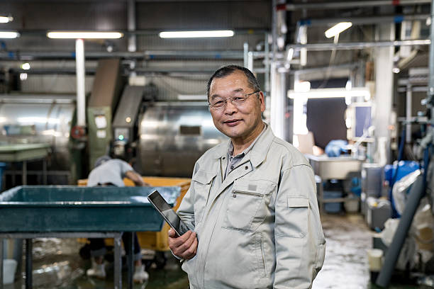 istock Sastisfied senior manager standing in a garment washing facility 537458904