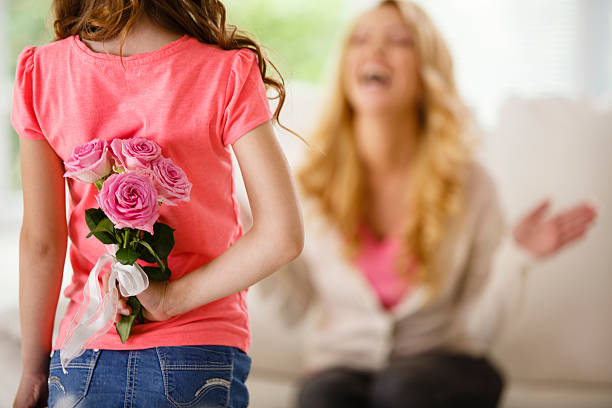 ragazza con bouquet di rose dietro la schiena, sorprendente madre - mothers day mother single flower family foto e immagini stock