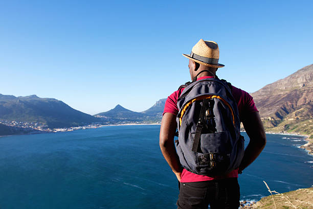 giovane africano in vacanza - mountain looking at view beach cliff foto e immagini stock