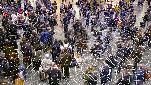 Cell phone radio signals in a crowd of people. Mobile devices sending out radio waves which spread out in a crowd of people. electromagnetic photos stock pictures, royalty-free photos & images