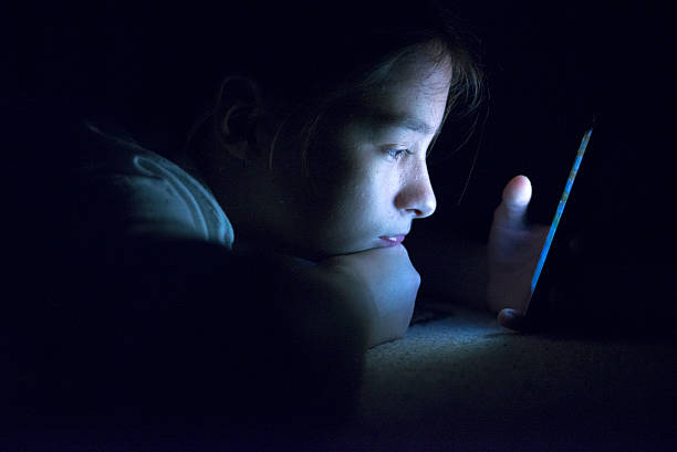 ティーンエイジャーメールを送る、ベッドの上にスマートフォン - addiction internet computer teenager ストックフォトと画像