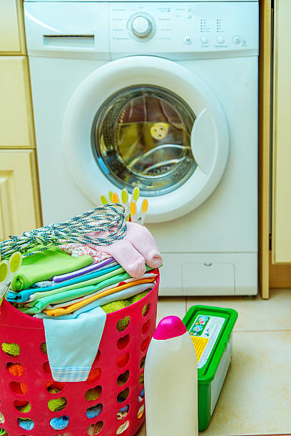 istock washing machine and a basket of child clothes 537462528