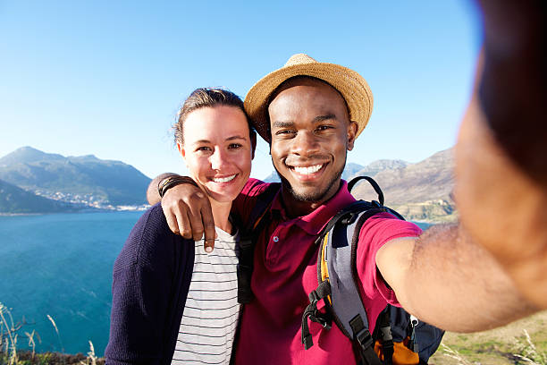 istock Smiling young couple on vacation taking selfie 537463098