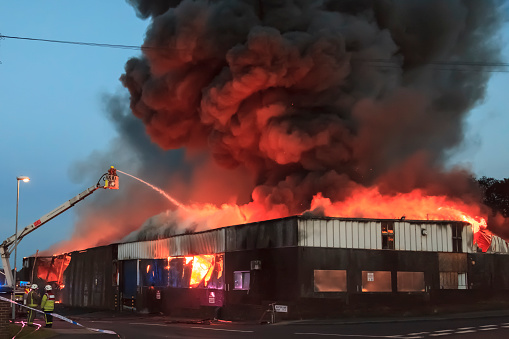 Leeds, UK - May 30, 2016: Firefighters tackling a large fire at a warehouse in Bramley, Leeds. The firefighters had been fighting the fire for roughly an hour at this point but the building could not be saved.