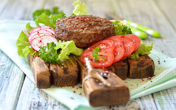 istock Meat grilled burger on a wooden board with vegetables 537465944