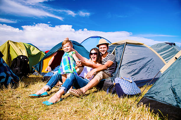 Young couple with their baby daughter in tent, summer Young couple with their baby daughter in a tent at summer music festival music festival camping summer vacations stock pictures, royalty-free photos & images