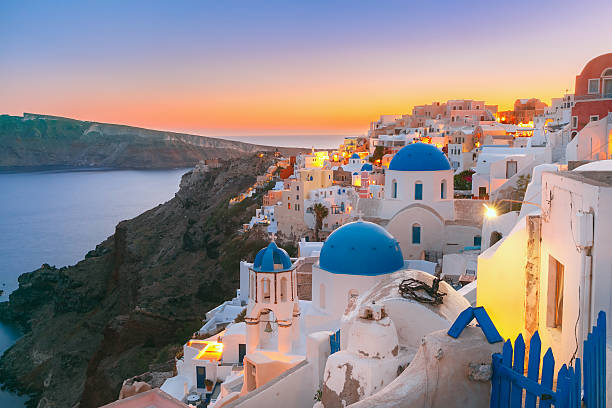 Oia at sunset, Santorini, Greece Picturesque view, Old Town of Oia or Ia on the island Santorini, white houses and church with blue domes at sunset, Greece santorin stock pictures, royalty-free photos & images